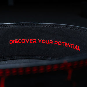 Inside of a red Unlisted Strength lever belt with the text 'discover your potential'