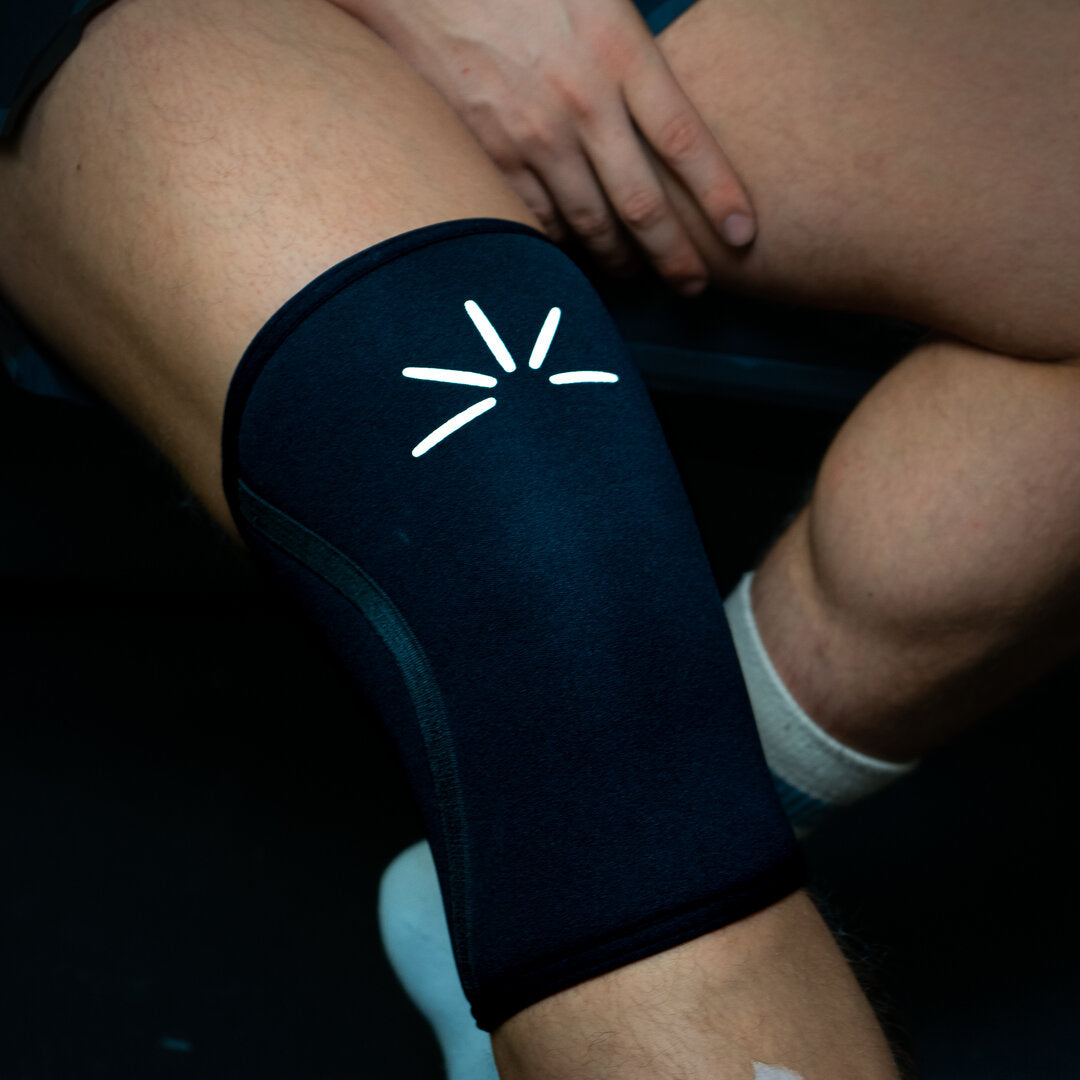 Close-up of black Trackfie knee sleeves on a man's knee