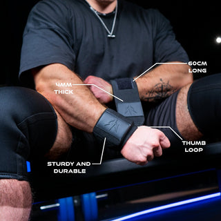 Man tightens his black wrist wraps around his wrist while specifications are highlighted with lines extending from them