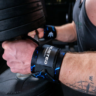 Close-up of blue wrist wraps on a man sitting with dumbbells